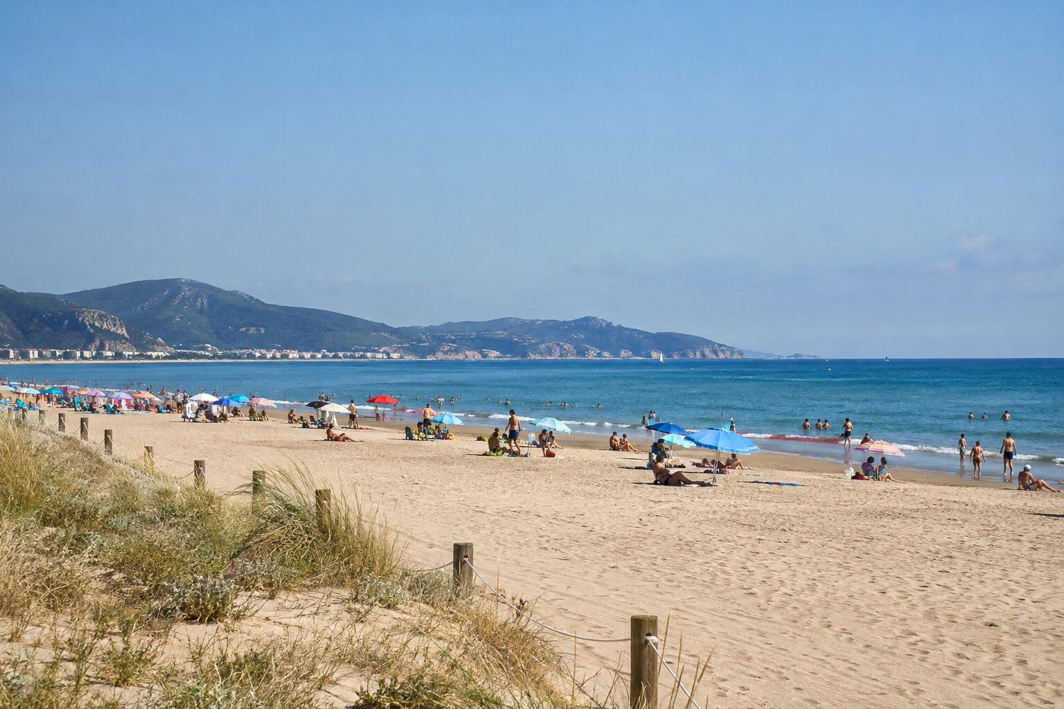 Broad sandy Castelldefels beach with umbrellas and calm water