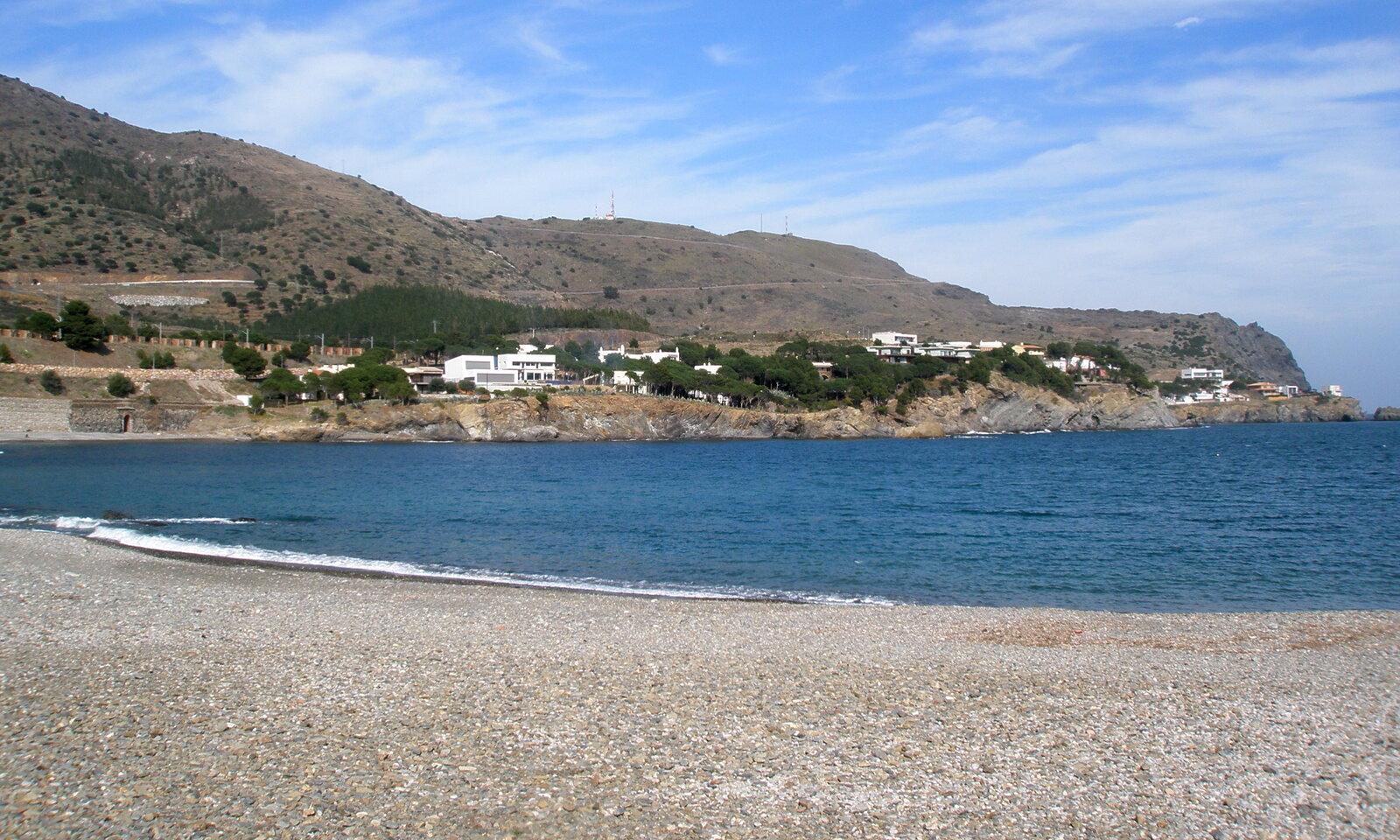 Colera’s pebble beach with houses across the bay